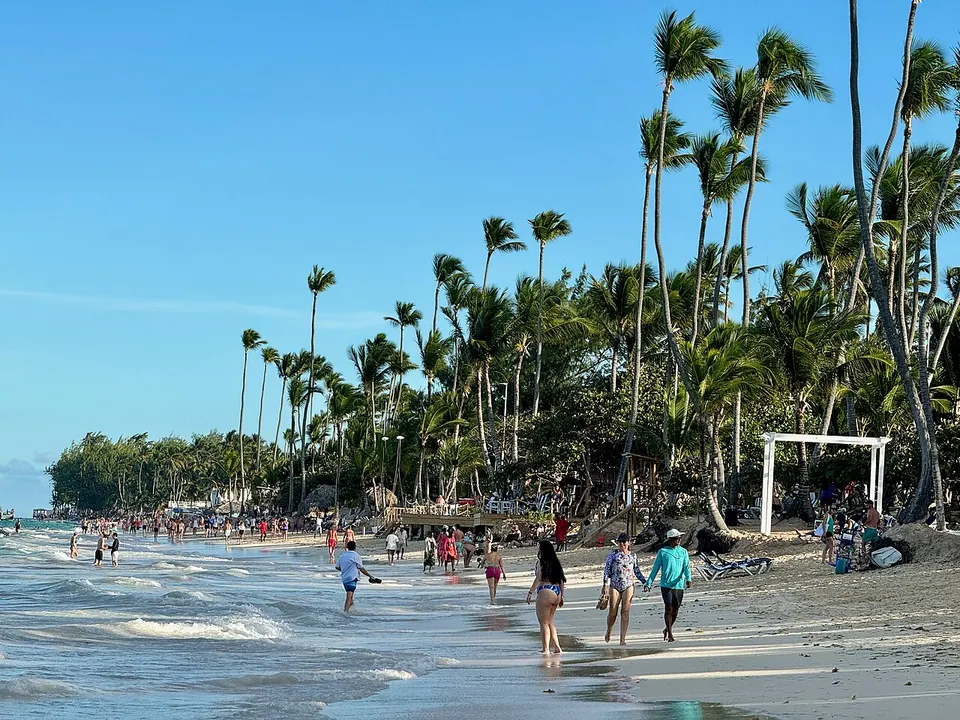 Weißer Sandstrand mit Palmen und türkisem Meer an der Playa Bávaro in Punta Cana