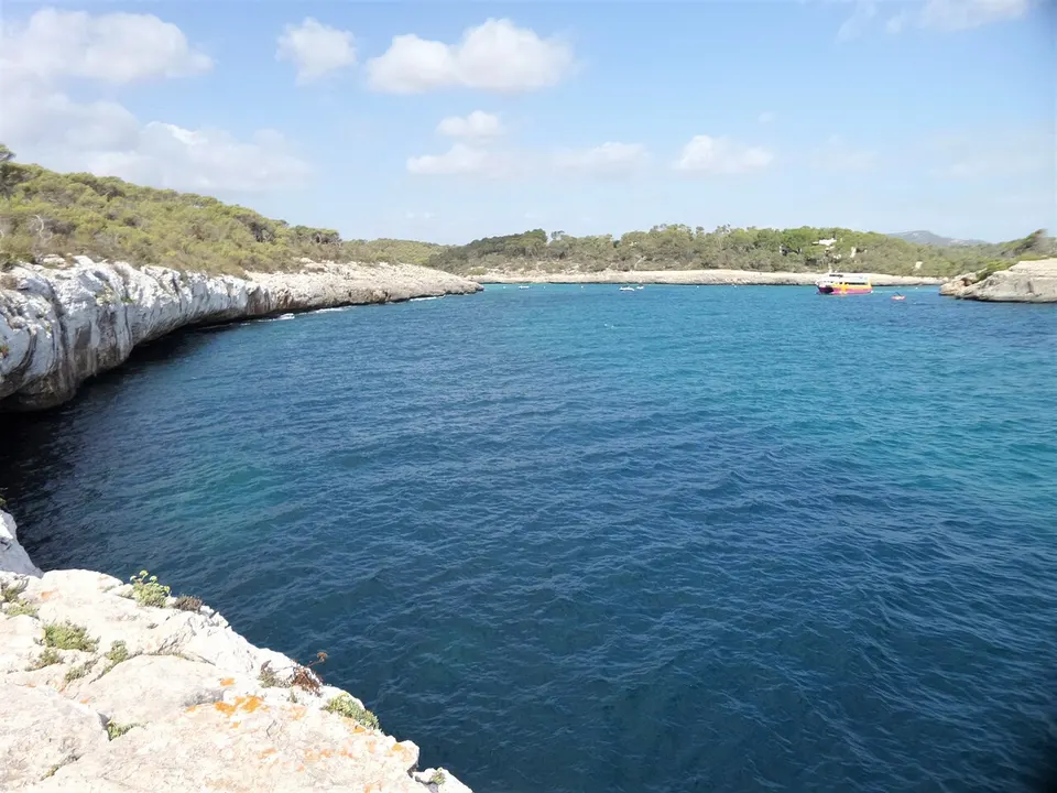 Türkisfarbenes Wasser und heller Sandstrand in der Bucht Cala Mondragó an der Ostküste Mallorcas