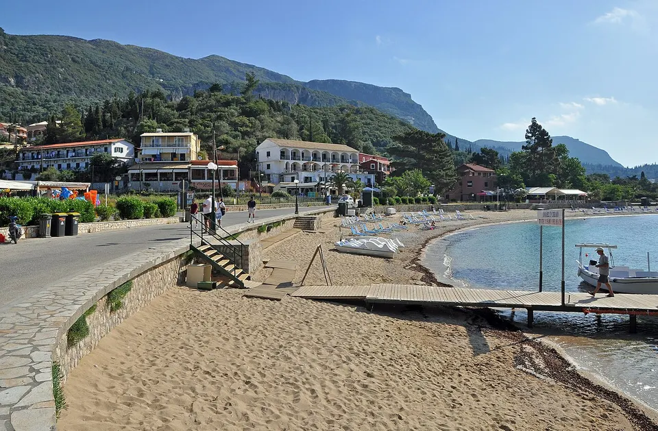 Bucht von Paleokastritsa auf Korfu mit Kiesstrand, türkisfarbenem Wasser und bewaldeten Hängen