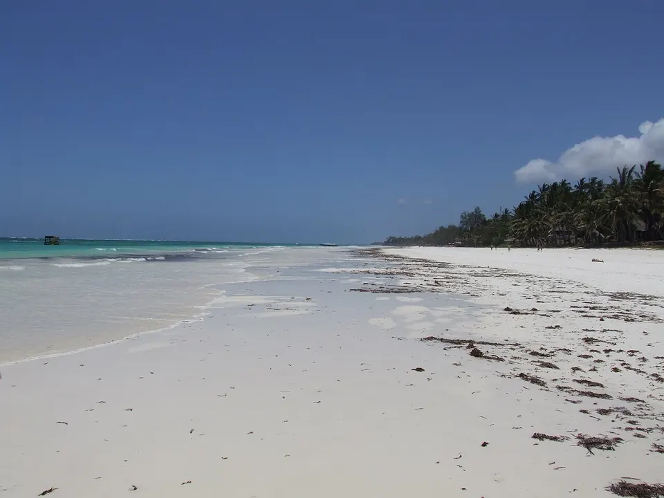 Weißer Sandstrand mit Palmen und türkisfarbenem Wasser am Diani Beach in Kenia