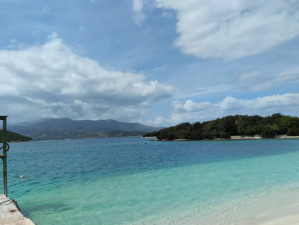 Strand von Ksamil in Albanien mit klarem türkisfarbenem Wasser und vorgelagerten Inseln