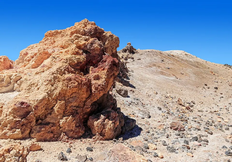 Der Vulkan Pico del Teide auf Teneriffa mit Lavafeldern und Ginsterbüschen im Vordergrund