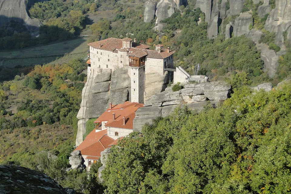 Das Kloster Roussanou auf einer Felssäule in Meteora, umgeben von grünen Hügeln